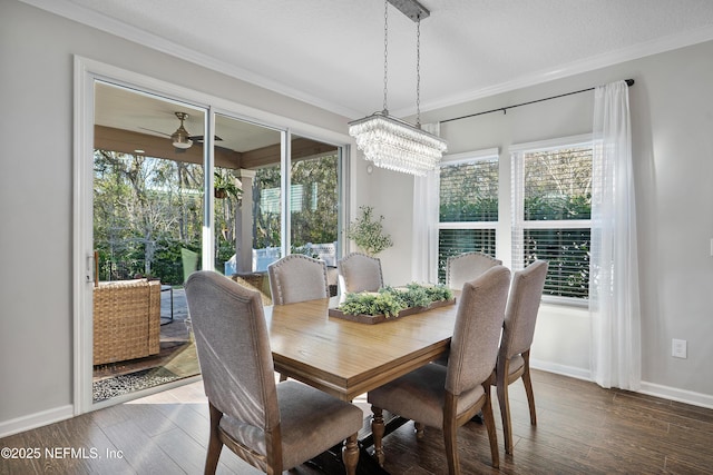 dining space featuring ceiling fan with notable chandelier, crown molding, baseboards, and wood finished floors