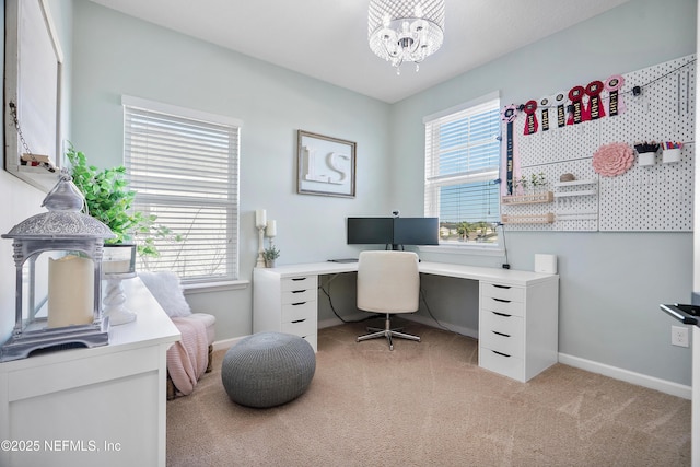 office space with baseboards, light carpet, and an inviting chandelier