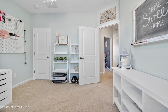 interior space with carpet flooring, visible vents, a textured ceiling, and baseboards