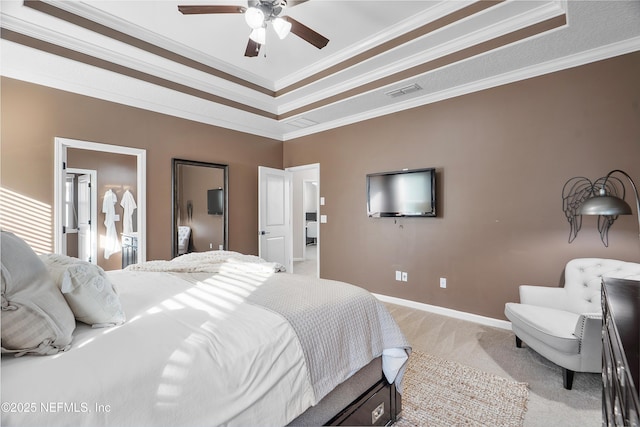 bedroom with visible vents, baseboards, a tray ceiling, ornamental molding, and light carpet