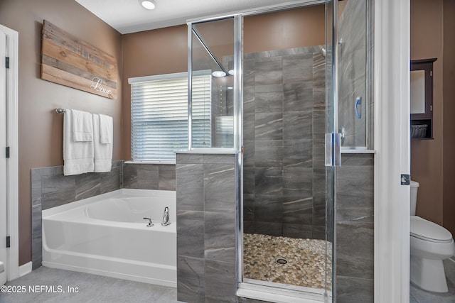 bathroom with a stall shower, toilet, and a garden tub