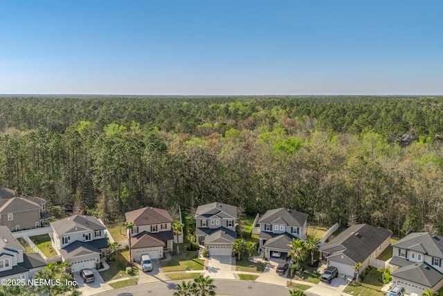 drone / aerial view with a forest view and a residential view