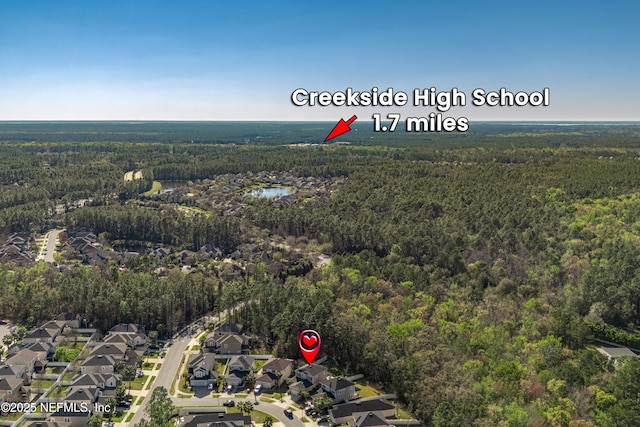 drone / aerial view featuring a residential view and a forest view