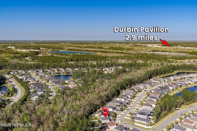 birds eye view of property with a forest view, a water view, and a residential view