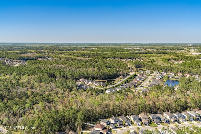 aerial view featuring a forest view, a residential view, and a water view