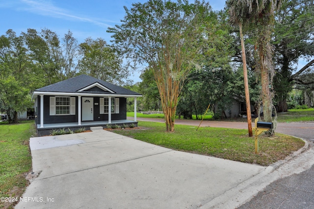 view of front of home featuring a porch, a front yard, and a shingled roof