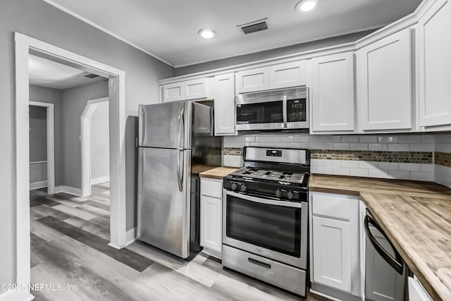 kitchen with tasteful backsplash, visible vents, appliances with stainless steel finishes, and wood counters