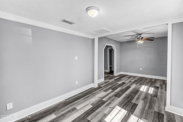 empty room featuring visible vents, ceiling fan, baseboards, attic access, and dark wood-style flooring