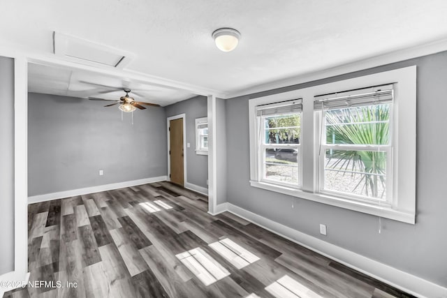 empty room featuring a ceiling fan, baseboards, and wood finished floors