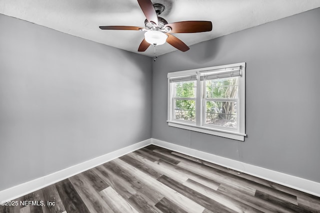 unfurnished room with ceiling fan, dark wood-type flooring, and baseboards