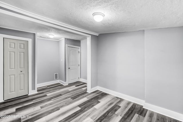 below grade area featuring visible vents, baseboards, and wood finished floors