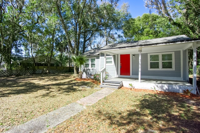 bungalow-style home featuring a front yard and fence