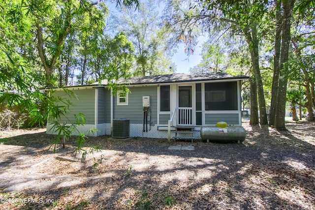 back of property featuring entry steps, central AC unit, and a sunroom