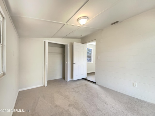 unfurnished bedroom featuring a closet, visible vents, baseboards, and carpet