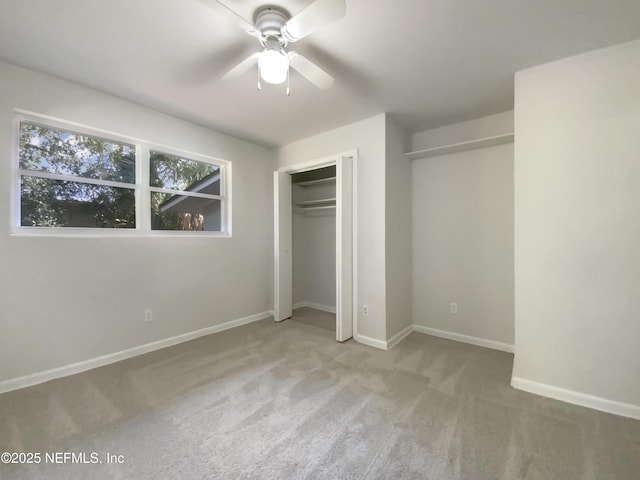 unfurnished bedroom with a closet, baseboards, carpet floors, and a ceiling fan