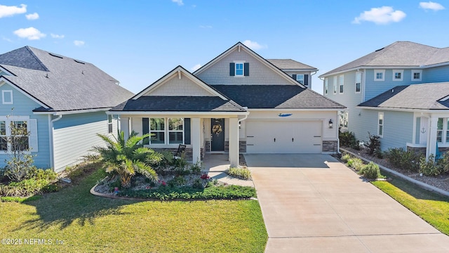 view of front of property with stone siding, concrete driveway, a front yard, a shingled roof, and a garage