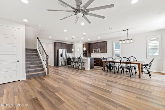 dining room featuring recessed lighting, visible vents, stairs, and light wood finished floors