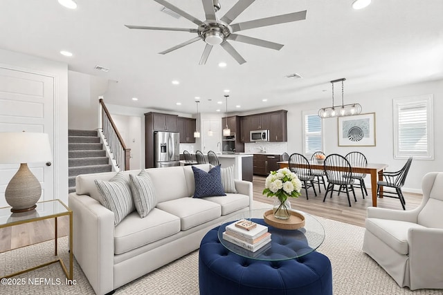 living area featuring stairway, recessed lighting, visible vents, and light wood-type flooring