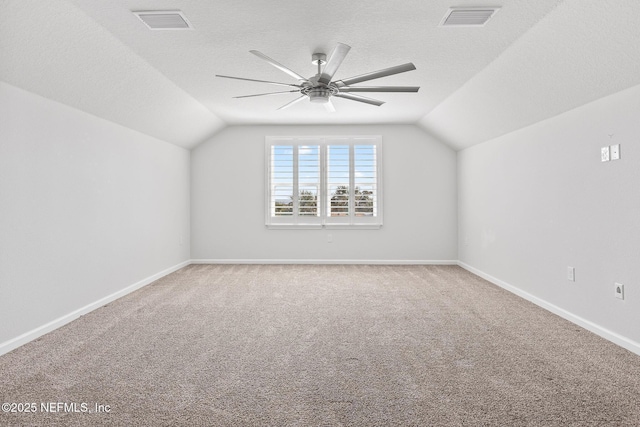 additional living space featuring lofted ceiling, visible vents, and a textured ceiling