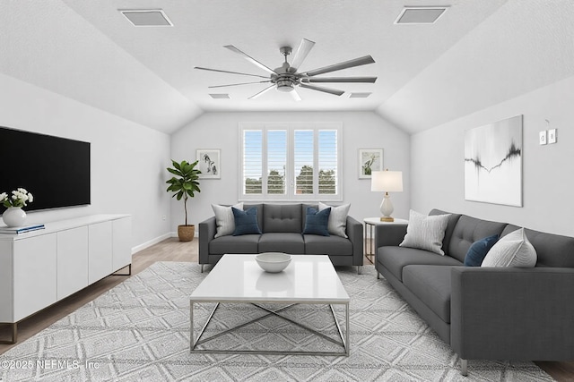 living area with light wood-type flooring, visible vents, ceiling fan, and vaulted ceiling