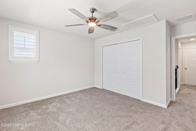 unfurnished bedroom with visible vents, attic access, baseboards, and carpet floors