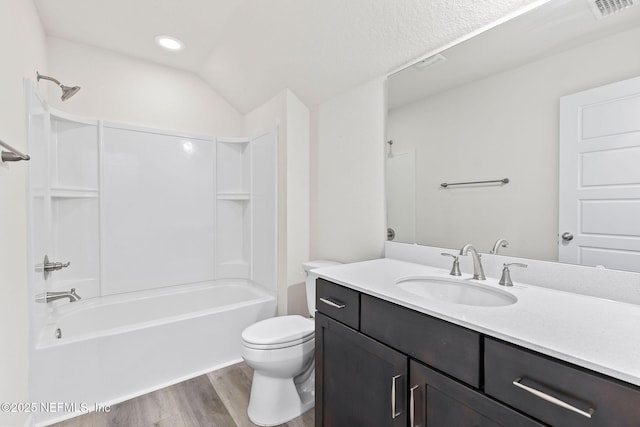 full bath featuring vanity, wood finished floors, visible vents, bathing tub / shower combination, and toilet