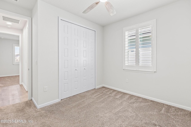 unfurnished bedroom featuring a closet, visible vents, baseboards, and carpet