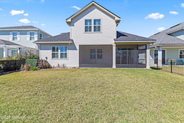 rear view of property featuring fence, a lawn, a shingled roof, and a sunroom