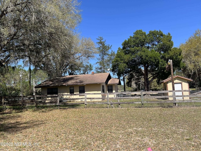 exterior space with a storage unit, an outbuilding, and fence