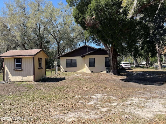 back of house with an outdoor structure and fence