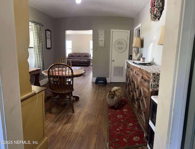 interior space with visible vents, dark wood-style flooring, and baseboards