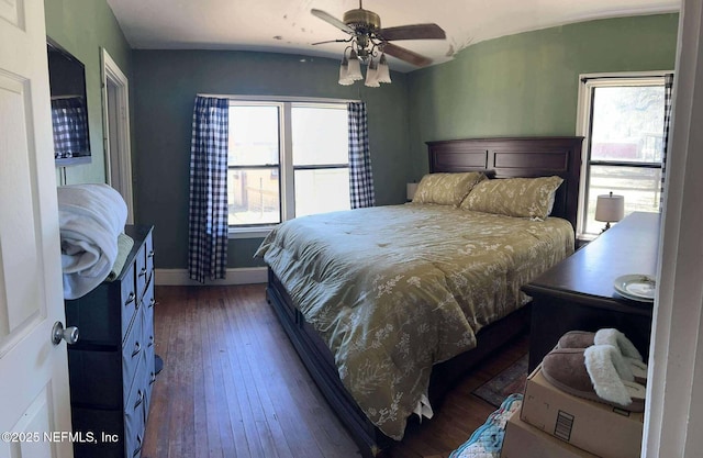 bedroom with dark wood-type flooring, multiple windows, a ceiling fan, and baseboards