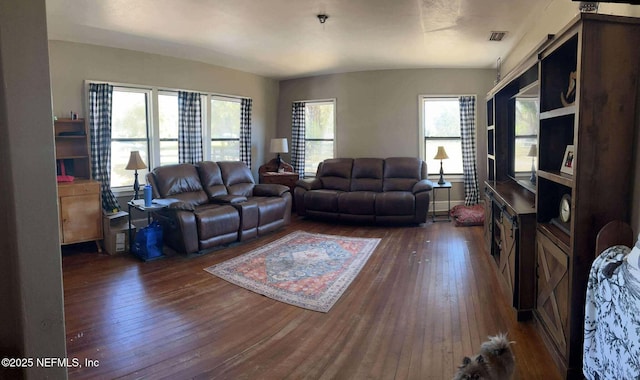 living area featuring visible vents and dark wood-type flooring