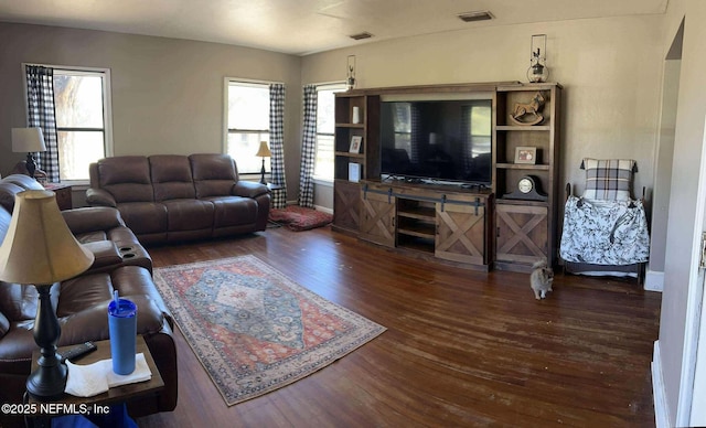 living room featuring visible vents, baseboards, and wood finished floors