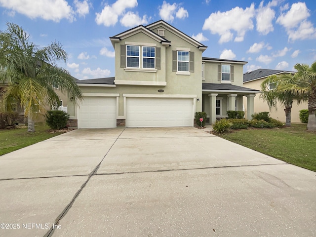 traditional-style home with a front lawn, an attached garage, driveway, and stucco siding