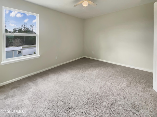 carpeted spare room featuring baseboards and ceiling fan