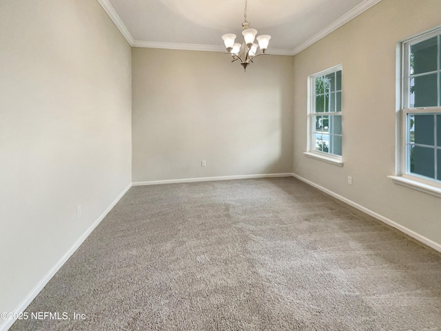 empty room with a chandelier, carpet flooring, crown molding, and baseboards