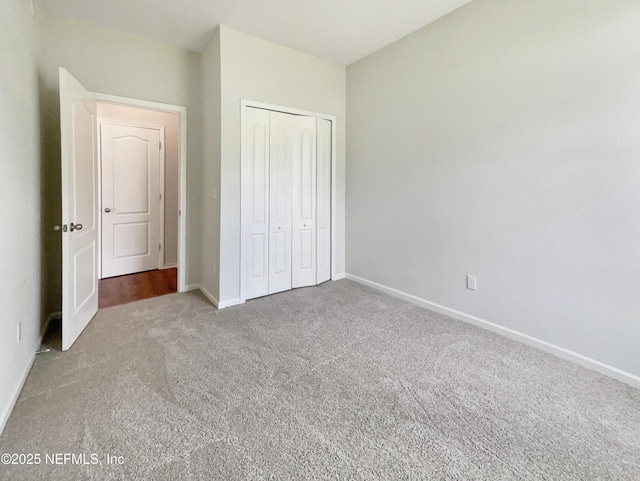 unfurnished bedroom with a closet, baseboards, and carpet flooring