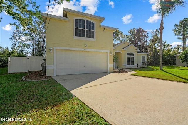 view of front facade with stucco siding, driveway, a front lawn, fence, and a garage