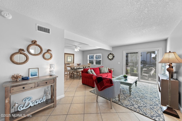 living room with light tile patterned floors, visible vents, a wealth of natural light, and a textured ceiling