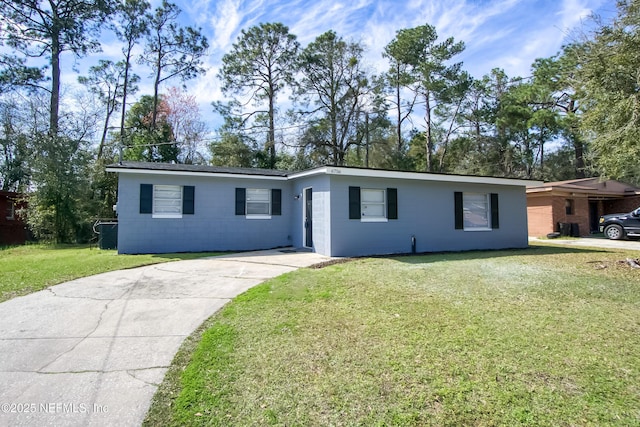 ranch-style home featuring concrete block siding, central AC, and a front yard