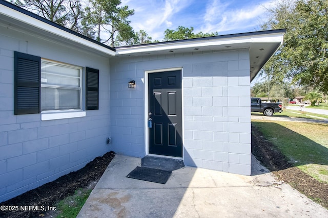 doorway to property with concrete block siding