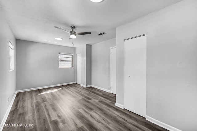 spare room featuring ceiling fan, wood finished floors, visible vents, and baseboards