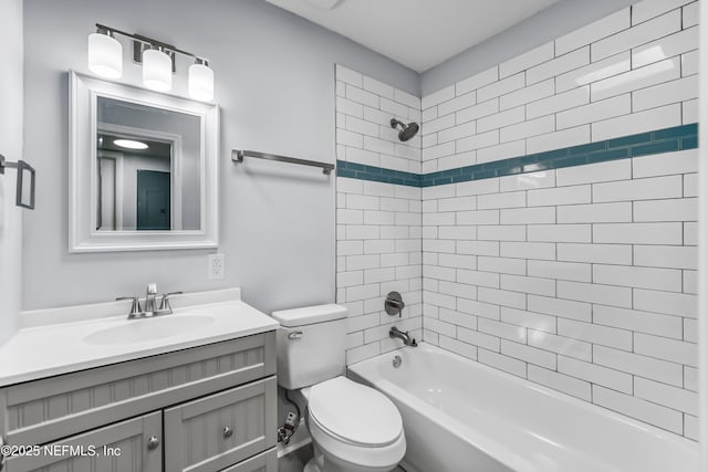 bathroom featuring vanity, toilet, and  shower combination