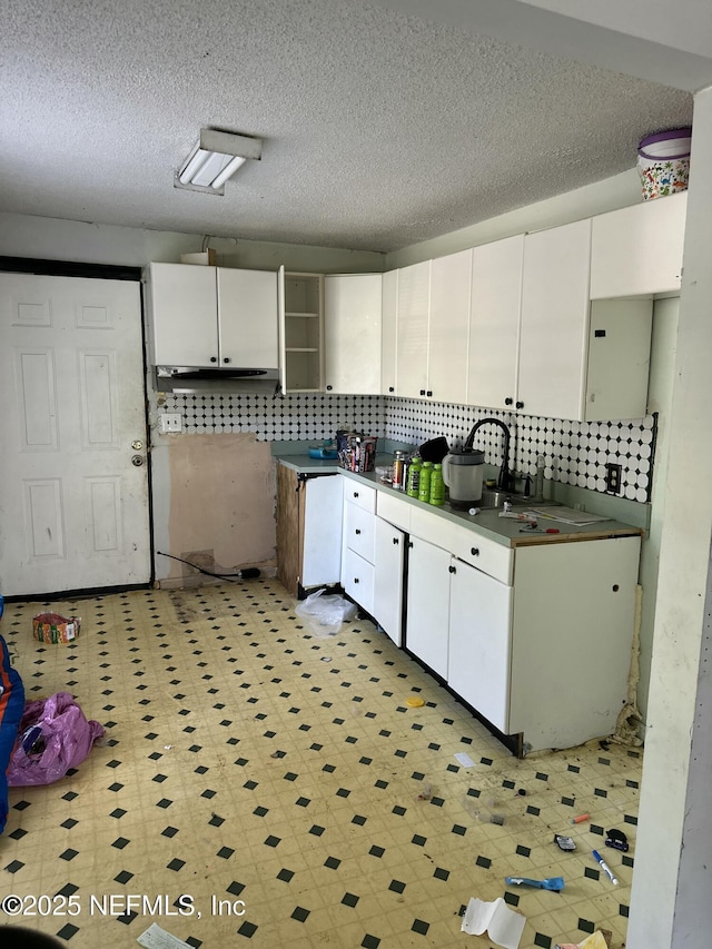 kitchen featuring tasteful backsplash, white cabinets, and a textured ceiling