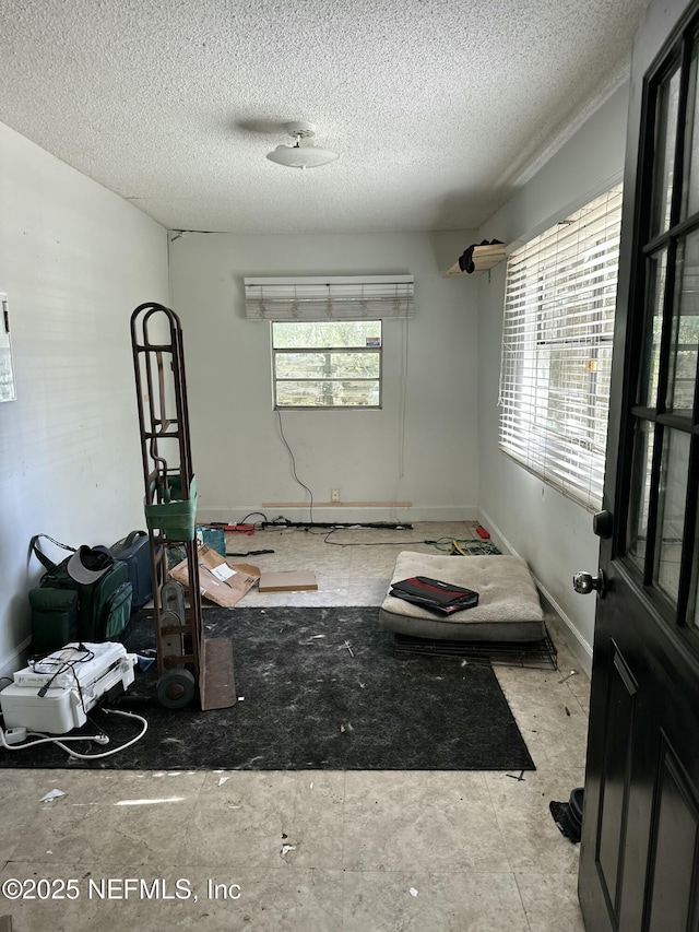 unfurnished room with baseboards and a textured ceiling