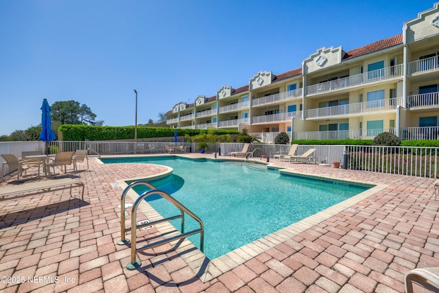 community pool featuring a patio area and fence