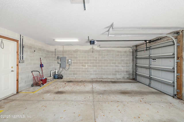 garage with electric panel, concrete block wall, and a garage door opener