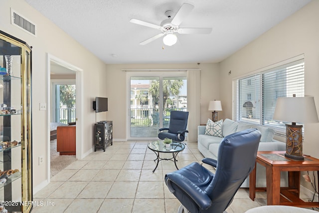 living room with light tile patterned floors, visible vents, a healthy amount of sunlight, and ceiling fan