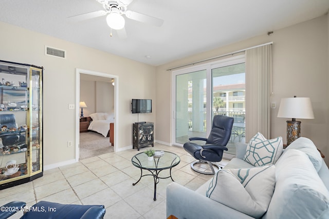 living area with light tile patterned flooring, baseboards, visible vents, and ceiling fan